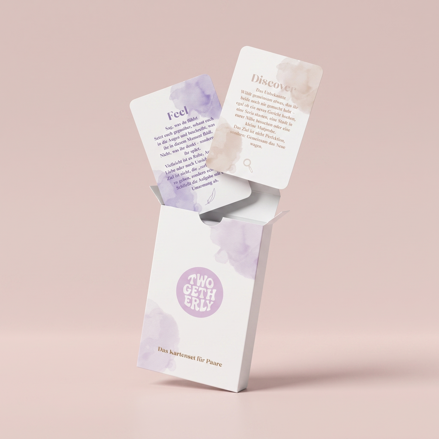 Geöffnete Verpackung der Date Cards mit zwei herausschwebenden Beispielkarten aus den Kategorien Feel und Discover